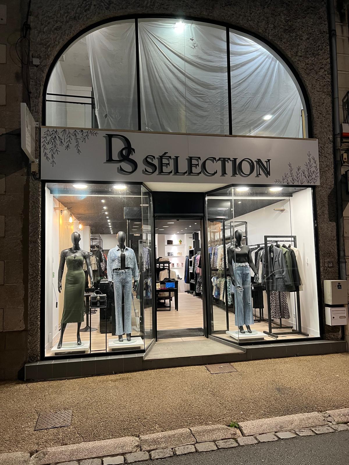 Façade de la boutique DS Sélection à Cholet de nuit, avec ses vitrines éclairées présentant des tenues féminines.