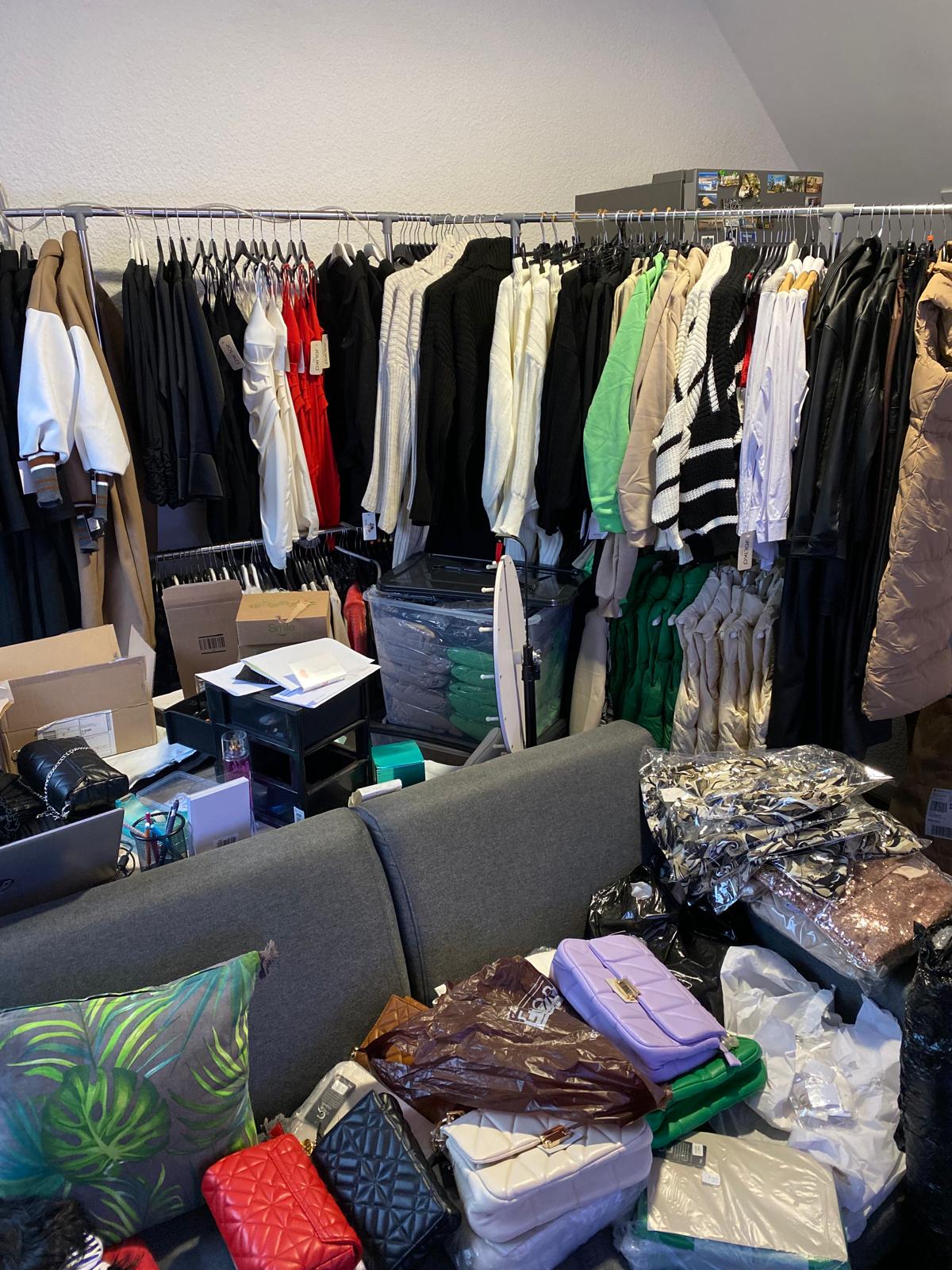 Portants de vêtements, cartons et sacs à main entreposés dans une pièce lors des débuts de DS Sélection.